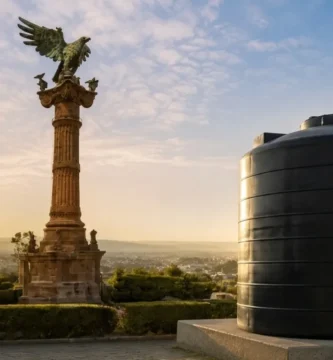 Tinaco negro de gran capacidad instalado en un mirador con vista panorámica al monumento del águila en San Juan del Río, Querétaro.
